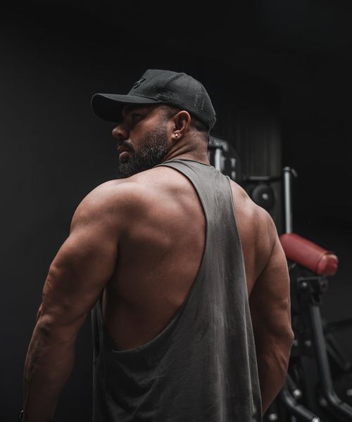 Man demonstrating a powerful core exercise in a dark room with pink light.