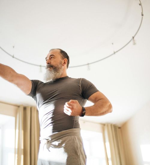 Man feeling energized and stretching in a bright, open space.
