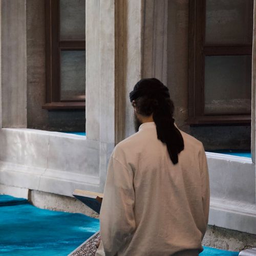 Silhouette of a man in a meditative pose against a calm background.